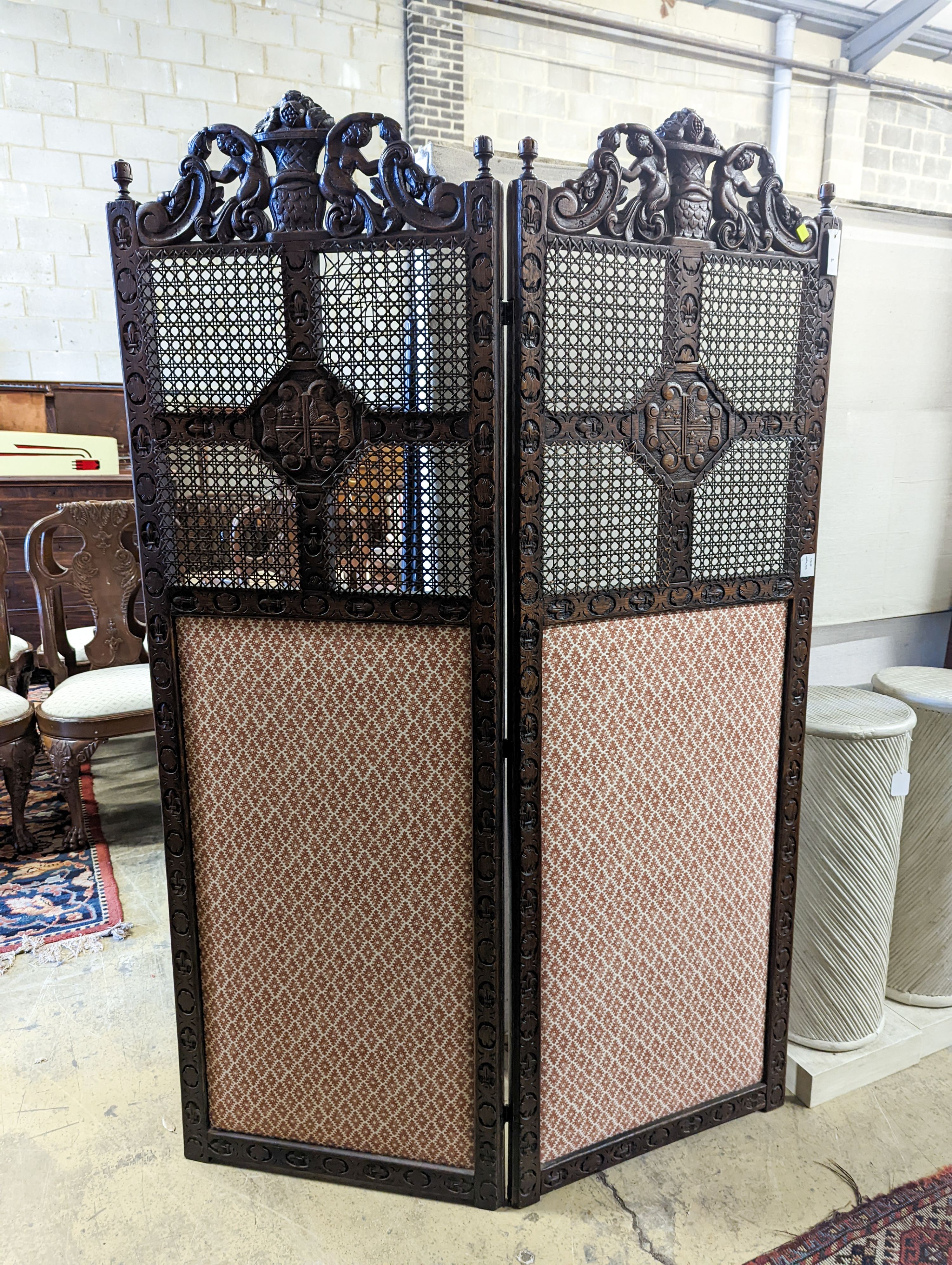 A 1920's Carolean style oak and cane work two fold dressing screen, each panel width 60cm, height 182cm